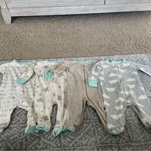 Four long sleeve onesies/ footie pajamas by Gerber in a size 0-3 months.